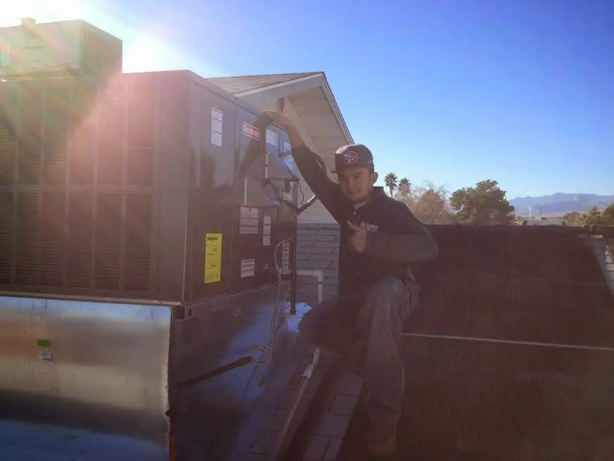 HVAC technician performing AC Tune-Up on a rooftop unit in Largo